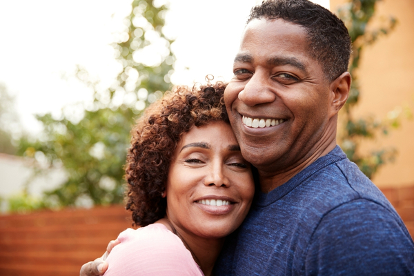 A smiling man and woman embracing closely.